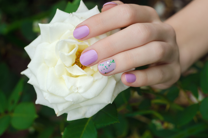 Female hands with lilac nail design.