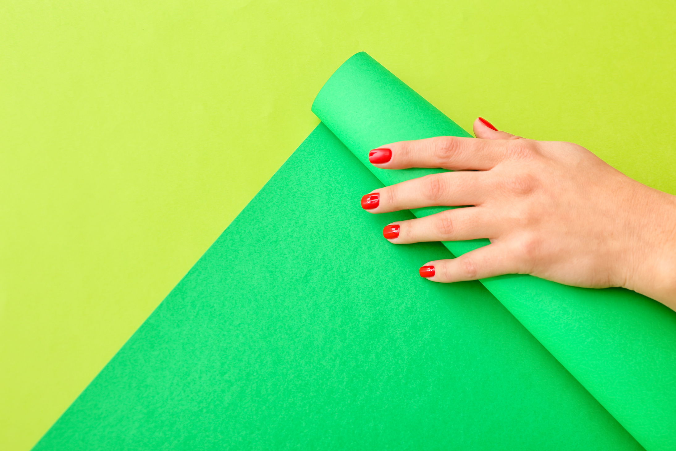 Female Hand with Beautiful Manicure on Green Background