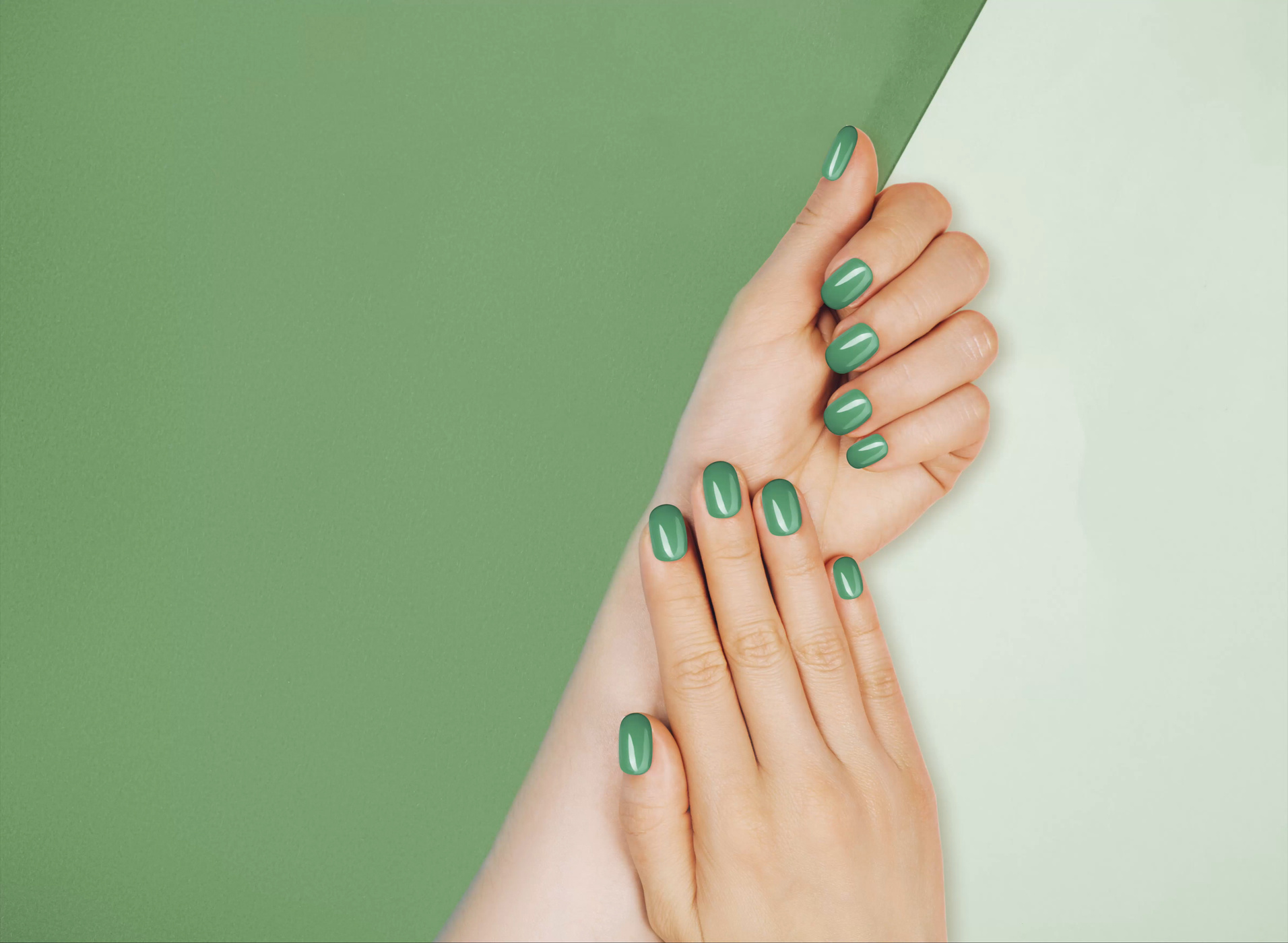 Closeup of hands of a young woman with green manicure on nails